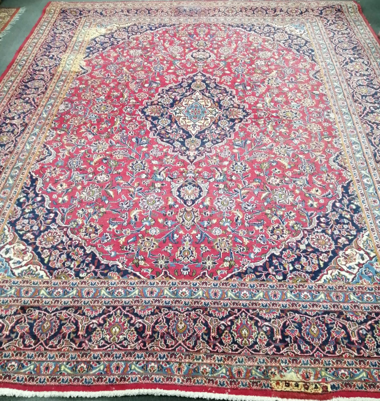A Persian red ground carpet, 377 x 291cm, some bleach stains *Please note the sale commences at 9am.